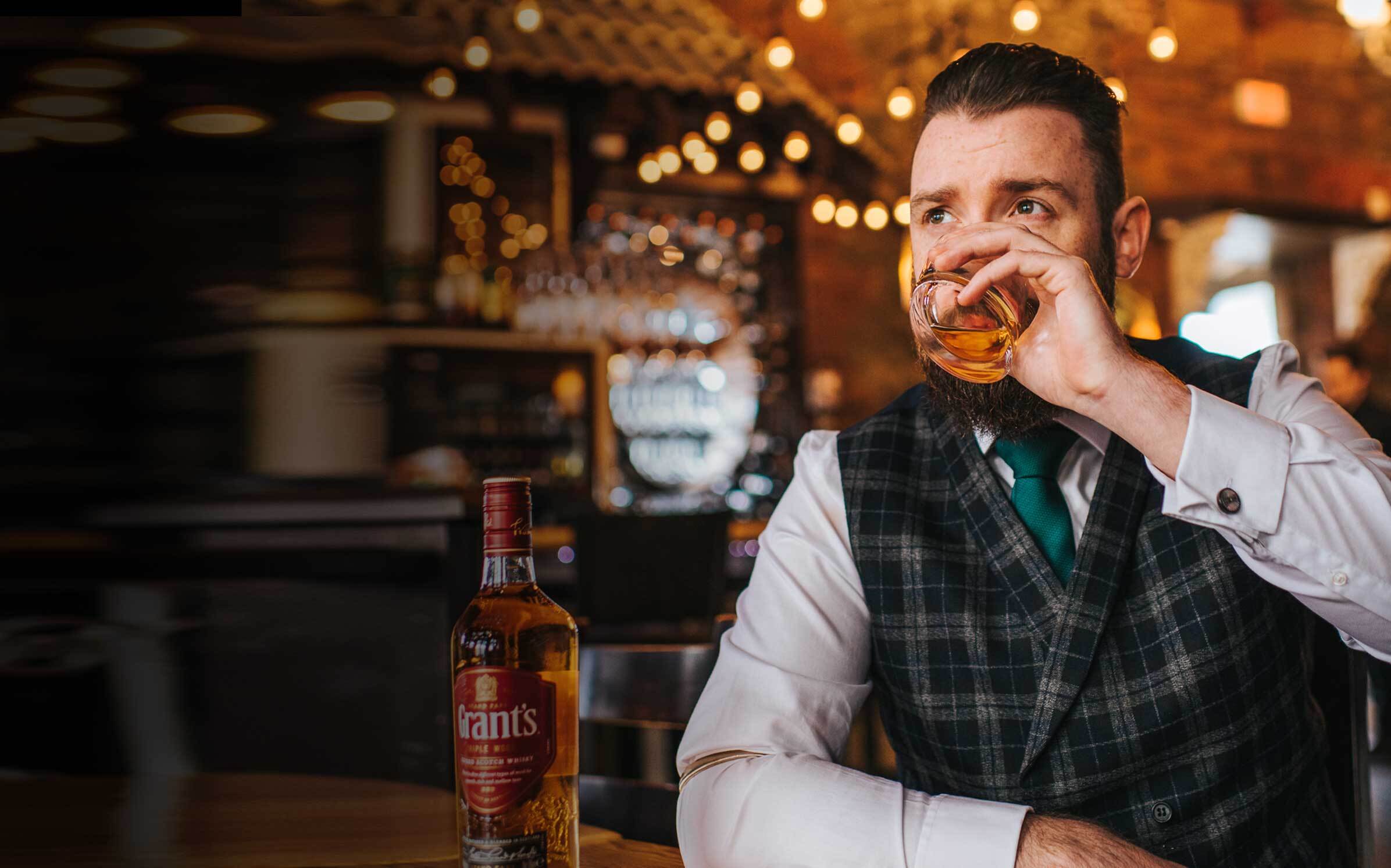 Grant's brand ambassador Danny Dyer drinking whisky in a bar