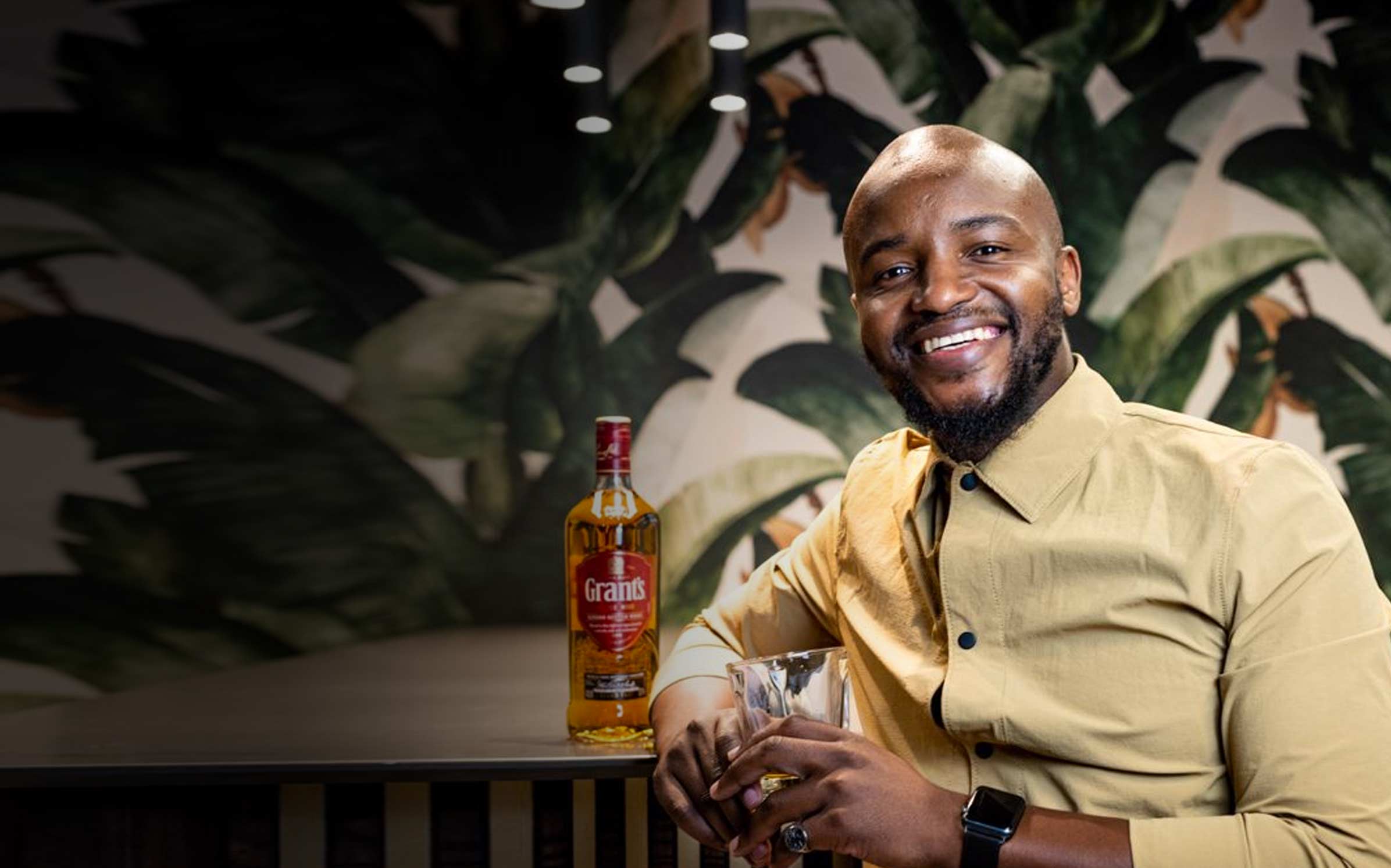 Grant's brand ambassador Sandile smiling with Grant's triple wood 12 bottle in background